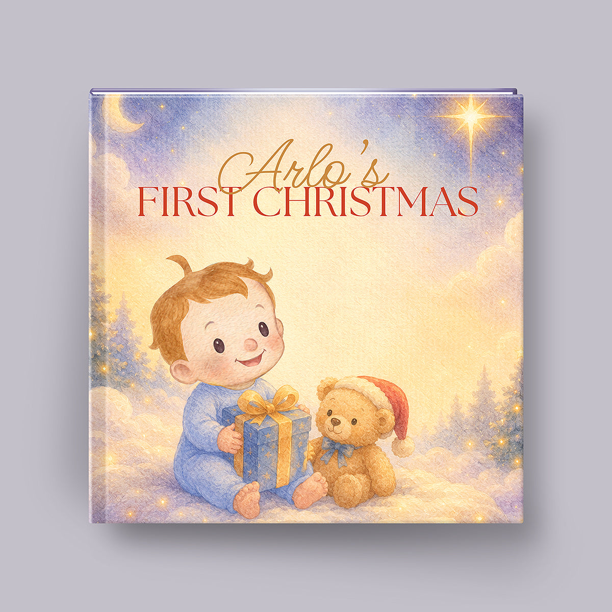 A square keepsake album or book cover titled 'Arlo's First Christmas' featuring an illustration of a baby in blue pajamas holding a gift box next to a teddy bear wearing a Santa hat, set against a snowy night scene with a star and moon. The book is photographed on a neutral gray background.