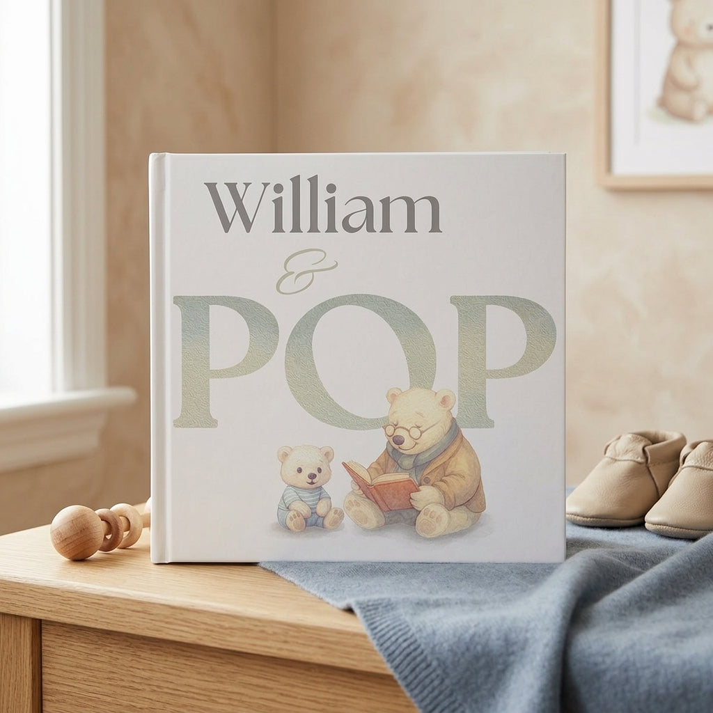 Personalized book titled 'William & Pop' with teddy bear illustration on a wooden surface.